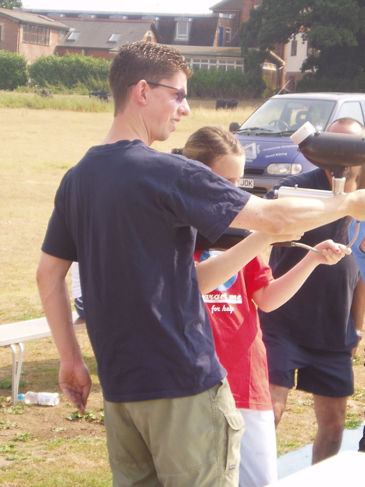 Jonathan supports the barrel of the gun as Amy fires